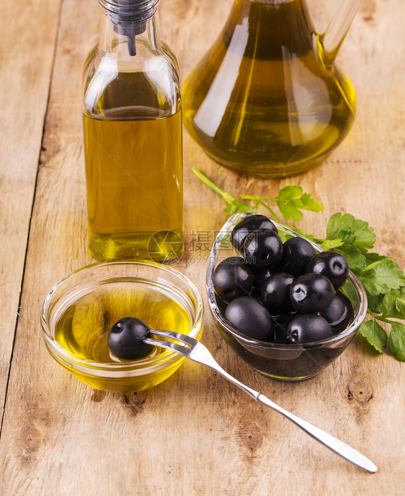 乡村液体烹饪维尔京橄榄油和健康的油瓶子和杯旧木制餐桌面上与食的欧利酒杯图片