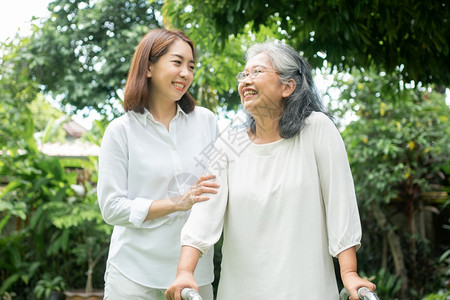 女儿陪母亲在花园散步背景图片