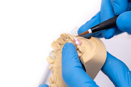 口服工作场所牙科技术员在其实验室内使用陶瓷牙植入器刷子图片
