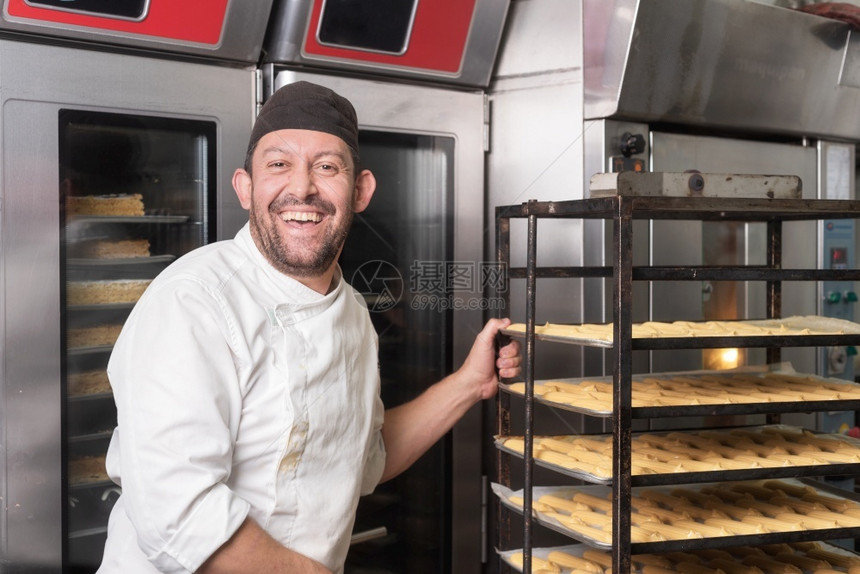 职业微笑贝克在面包店或糕点的烤箱里放一串糕饼然后在面包店或糕点把一包蛋放在烤箱里男糖果图片