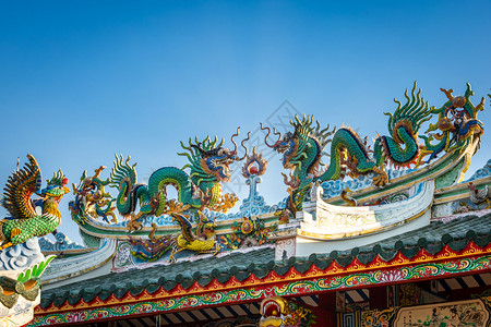 围龙屋美丽的双金龙雕像在天蓝的神庙新年庆典中华节的圣殿屋顶上装饰传统历史背景