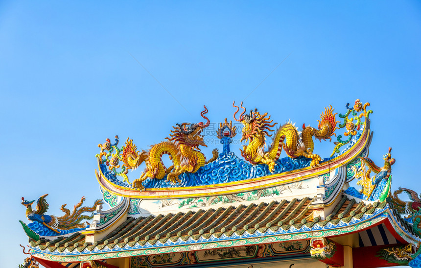 美丽的双金龙雕像在天蓝的神庙新年庆典中华节的圣殿屋顶上象征佛老的图片
