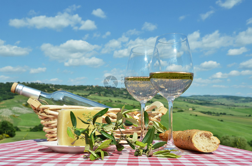 橄榄桌上的白葡萄酒与意大利托斯卡纳景观藤蔓优质的图片