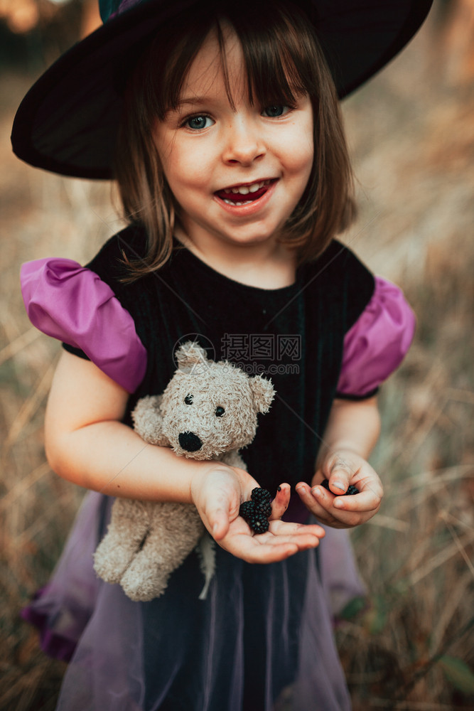 魔术师假期万圣节时在树林里装扮成的微笑孩紫色图片
