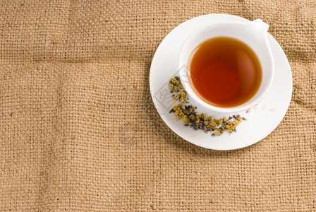食物黄色的红茶在白陶瓷杯中背景薄饼茶点图片