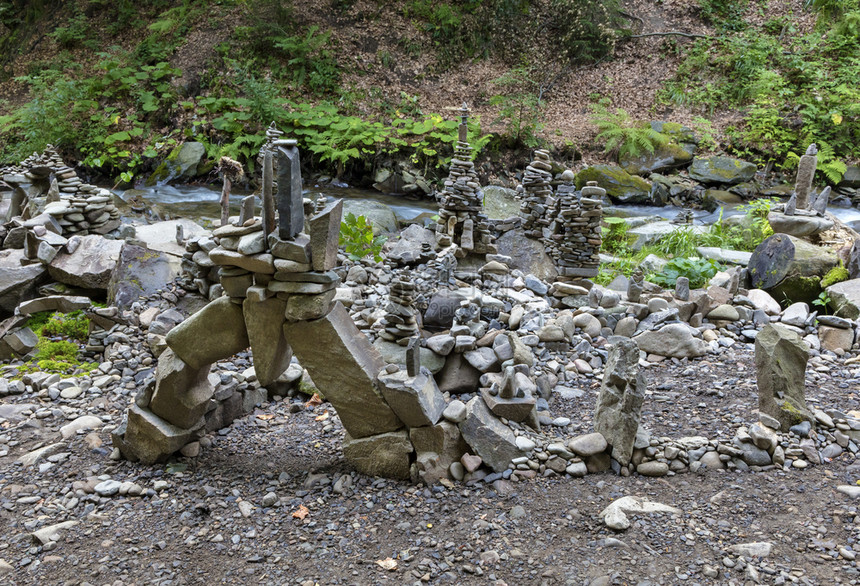 河边银行直觉喀尔巴阡山脉区河流岸边的平衡石塔金字和溪流两岸河卵石的雕塑溪流两岸河卵石的塔金字和雕塑图片