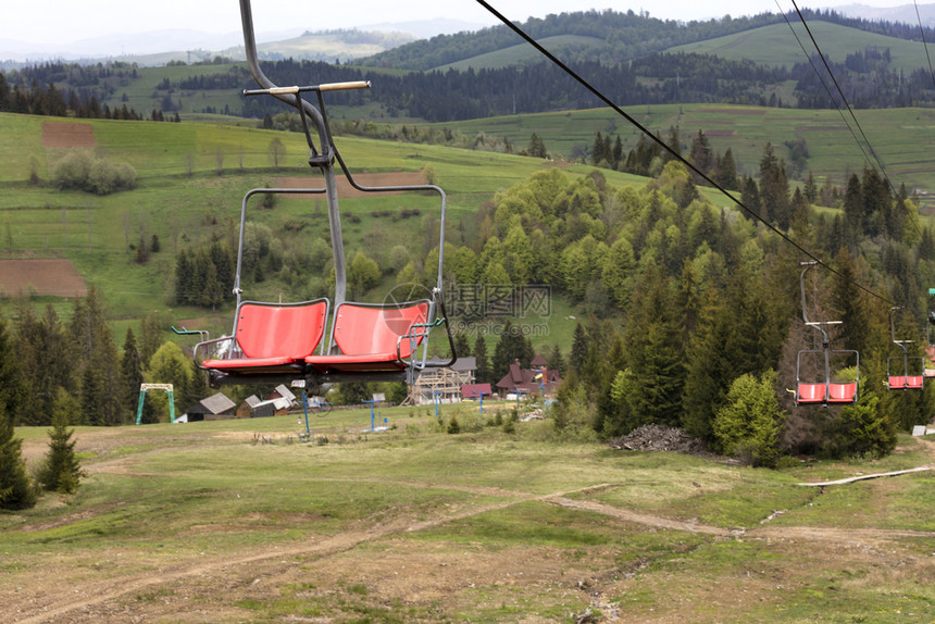 高山电梯一排椅子挂在条移动电缆上用于运送乘客上下山的轮椅并搭载卡尔帕特山脉的地景观森林夏天春图片