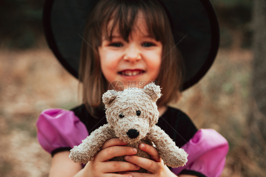 泰迪熊前夕万圣节时在树林里装扮成的微笑孩感恩图片