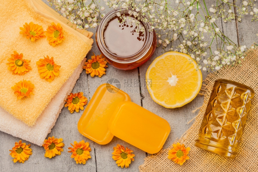 木制桌上的蜂蜜肥皂照片香水橙甘油图片