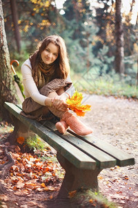 秋天公园的长椅上有叶子漂亮女孩短袜腿毛衣图片