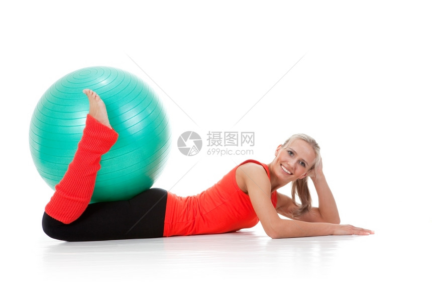 一个微笑的女士躺在地上带着双腿握球橙色绿和黑的颜她全身被射中健康讲师说谎图片