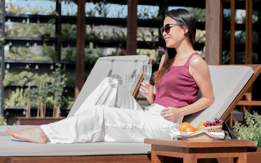 华林优雅的亚洲美丽女在渡假旅行和夏季概念的户外休息时冲晒太阳镜和喝酒葡萄女气质图片