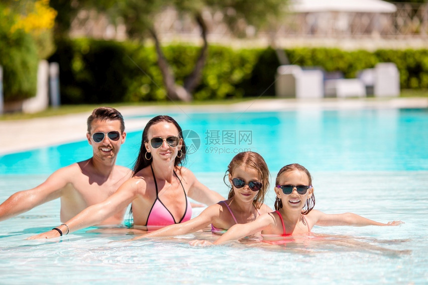 蓝色的有两个孩子年轻家庭在户外游泳池享受暑假有两名孩子的年轻家庭在户外游泳池享受暑假闲暇父亲图片