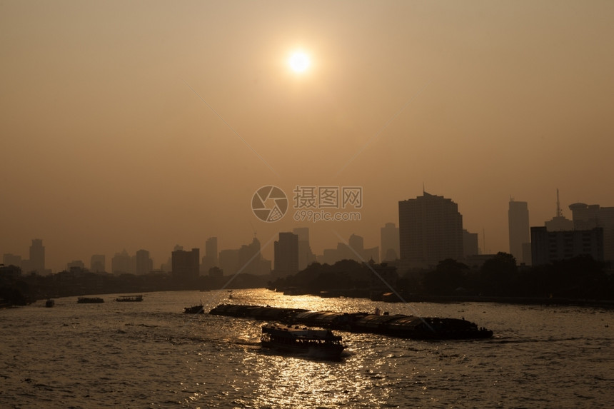 云曼谷市河上的船只交通清晨该市一幢高楼后面的曼谷市摩天大楼人们图片