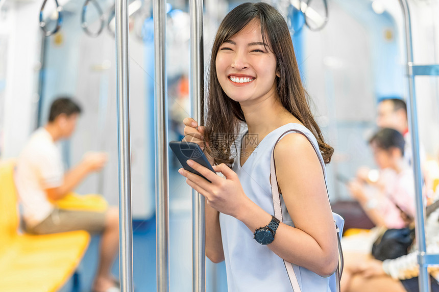 人群移动的亚洲青年女乘客在大城市japanesechinese朝韩生活方式和日常通勤和运输概念上旅行时通过地铁火车智能移动电话使图片