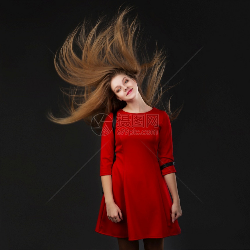 时尚一个微笑的年轻美丽女孩肖像穿着红色礼服与飞行头发女孩长流动头在运中飘金发女郎风图片