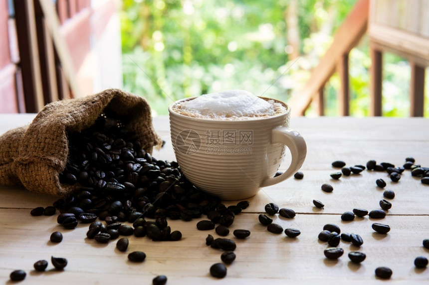 桌子豆卡布奇诺咖啡和豆在木材纹理背景早晨或咖啡时间餐浓图片
