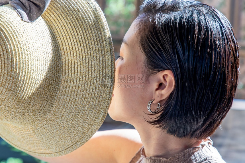 摆姿势亚洲人诱的年轻亚洲女和短发保持着帽子的紧身胸膜选择焦点图片