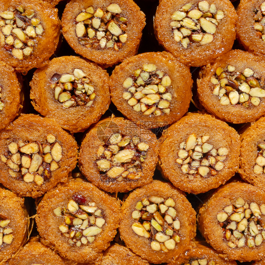 橙埃及人品尝土耳其美味甜的蜂蜜和坚果图片