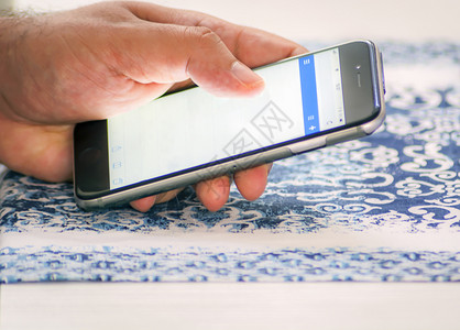工作展示网络男用智能手机对邮件进行检查用手指触摸屏幕图片