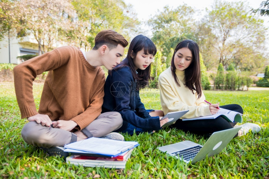 学生们在草坪上使用笔记本电脑图片