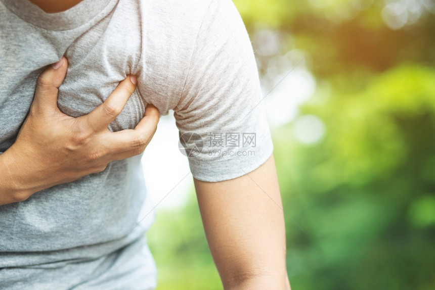 痛苦公园患有胸部疼痛的男子户外心脏病发作或严重锻炼导致身体震动心脏病重的图片