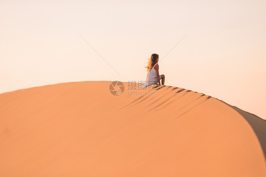 脊清除穿着白色连衣裙的小女孩在美丽沙漠中大丘度假阿拉伯联合酋长国沙漠丘中的女孩景观图片