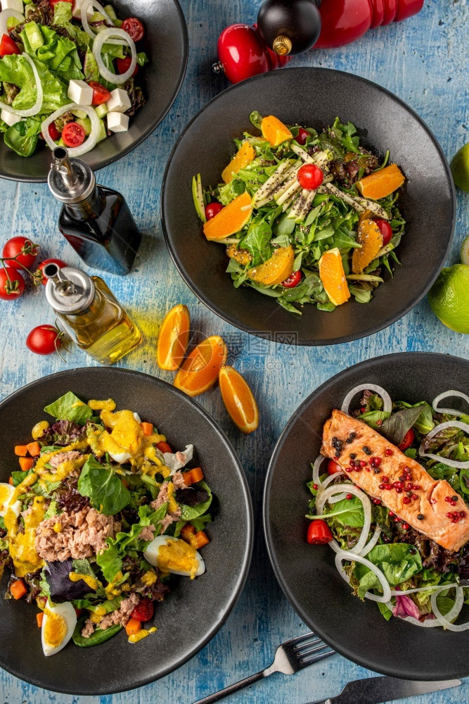 意大利面放四种不同类的沙拉在蓝石桌上新鲜服务番茄图片
