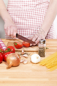 面条围裙烹饪切西红柿蔬菜做意大利面的手切番茄图片