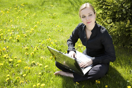 闲暇在笔记本电脑外面工作的年轻女士服装自由图片