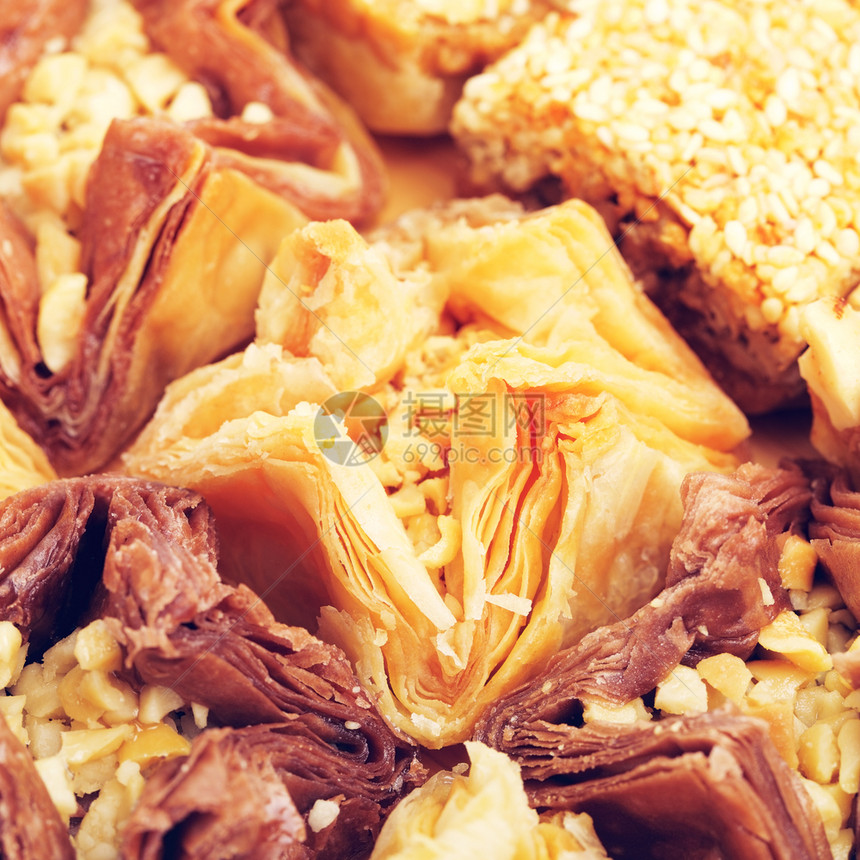 阿拉伯木制桌上的不同东方甜食baklava东方SweetBaklava美味的面团图片