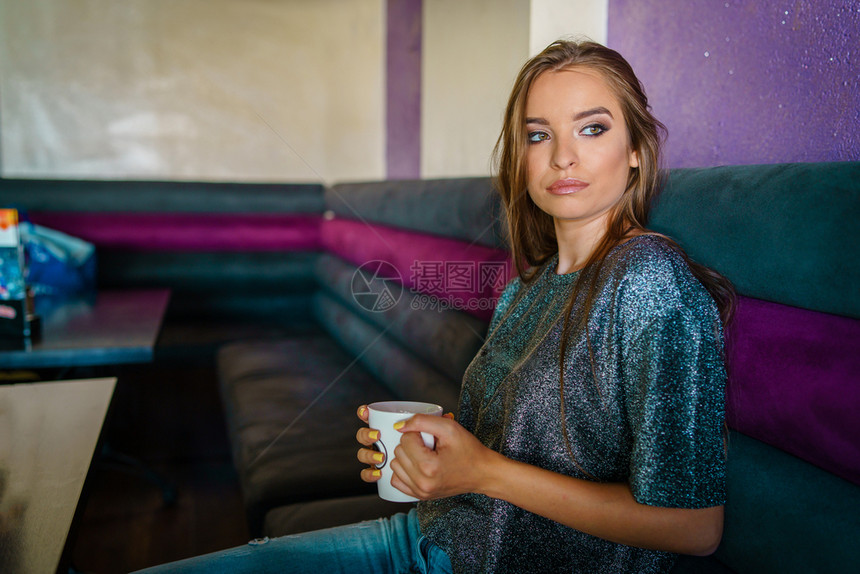 在室内咖啡店请享用独自坐在咖啡厅喝或茶的年轻美女孩肖像笑声图片