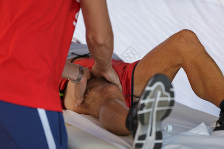 按摩放松运动员腿部的理疗师图片