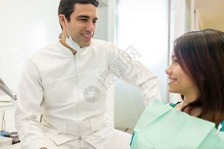 药物女士与办公室病人交谈的亚裔男牙医照片在办公室里诊所图片