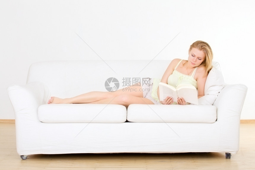 在家沙发上看书的可爱年轻女孩美丽休息闲暇图片