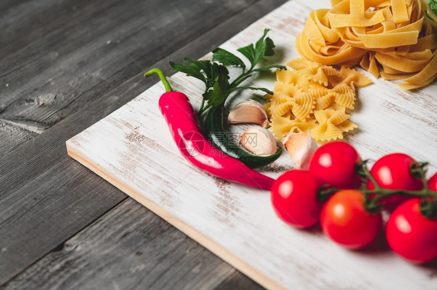 自然意大利面烹饪用番茄奶酪干面食橄榄油fettucenne和木制棕色桌边的烤肉意大利菜自制方食谱美品厨房图片