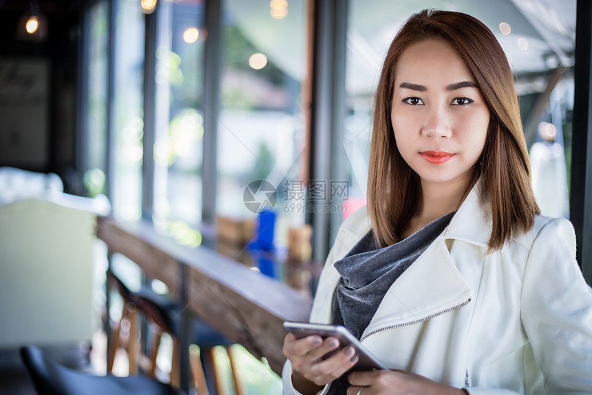 使用电话在线购物和自由时间在咖啡店用手机打电话的女亚洲人Asiian眼镜沟通漂亮的图片