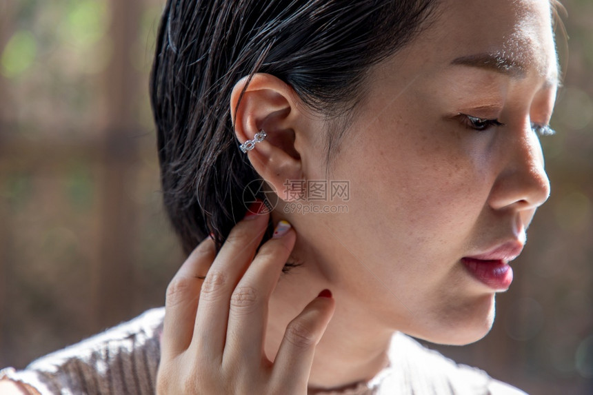 闲暇吸引人的尖端近距离拍摄一位亚洲年轻女脸庞和触摸她黑短发的小指尖肖像图片