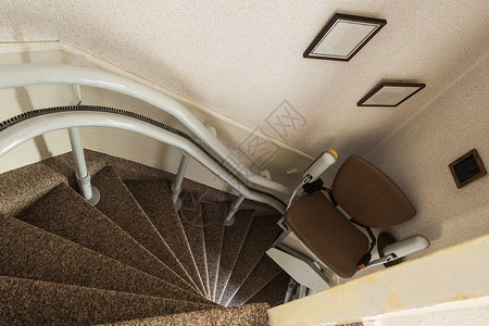 帮助倾斜的移动带残疾人或老年上下楼梯的机械升降椅老年人家庭残疾用楼梯带残疾人或老年上下楼梯的机械升降椅老年人残疾楼梯背景图片