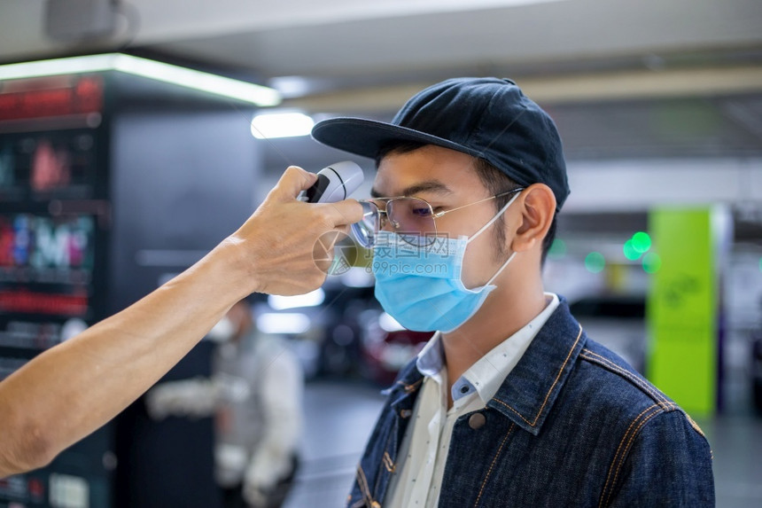 病人亚洲测量流感的温度检查科罗纳他脸上戴防护面具脸部戴着保护面具安全新冠图片