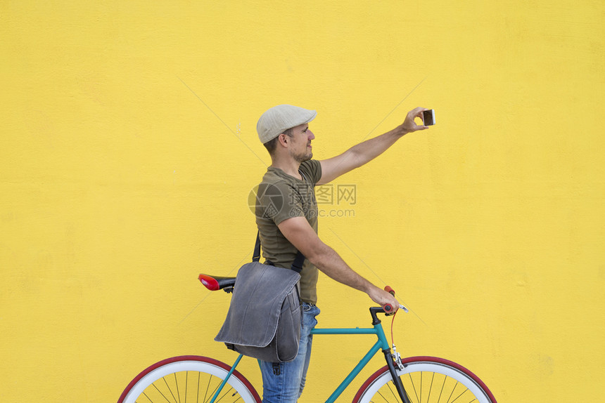 电话照片肖像他搭乘通勤有固定的轮子自行车生活方式旅行和可持续概念他正在上下班有固定的轮椅自行车图片