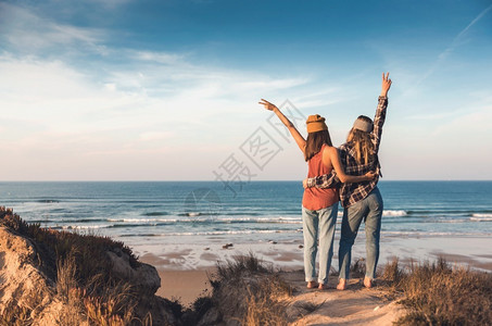 两个在海岸线附近的好朋友玩得开心手张闲暇海滨友谊图片