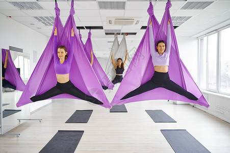 健身房练习空中瑜伽的运动女性图片