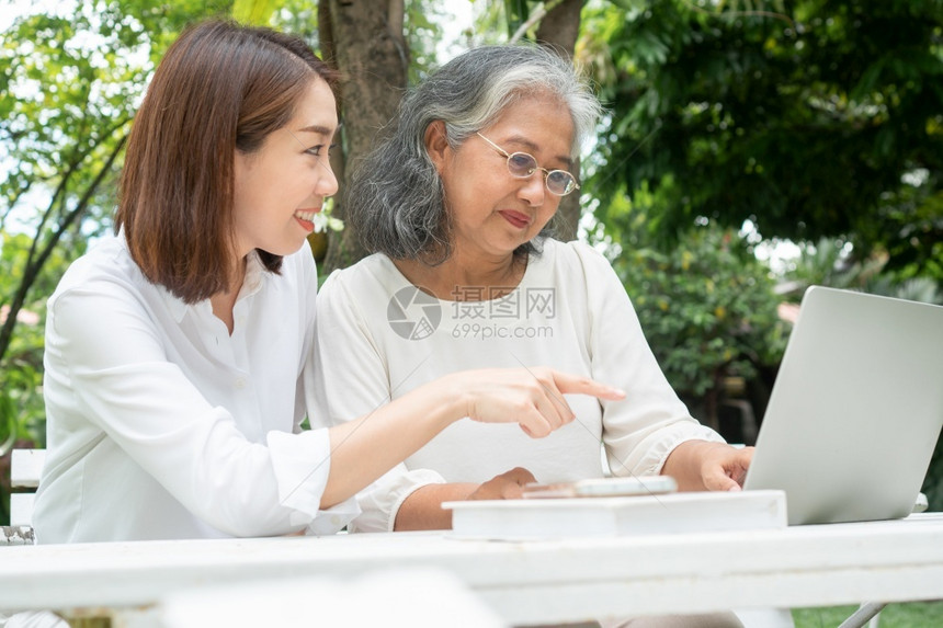女士退休后学习技术概念和老年人适应改造亚洲女儿教育年长妇使用计算机笔记本电脑手提在线社交媒体教授年长老妇女的亚洲儿祖母健康图片