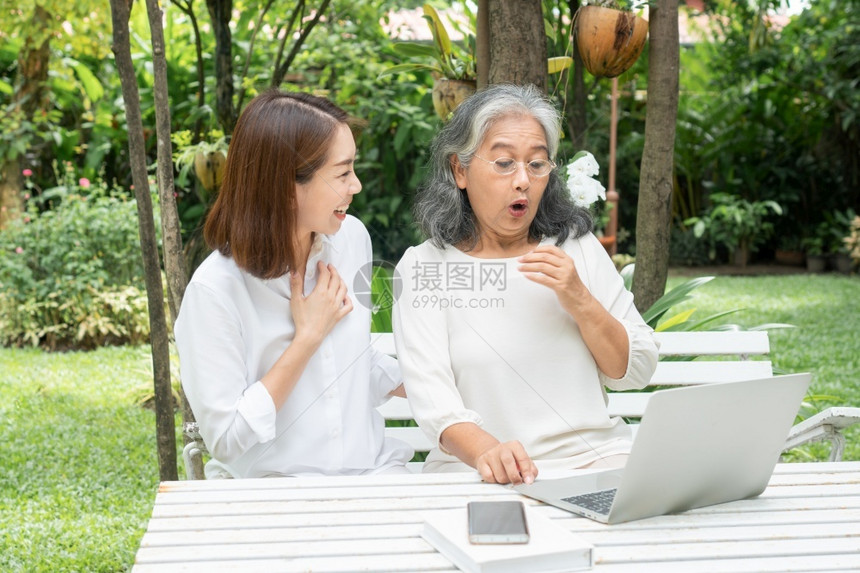 护士退休后学习技术概念和老年人适应改造亚洲女儿教育年长妇使用计算机笔记本电脑手提在线社交媒体教授年长老妇女的亚洲儿成熟看护人图片