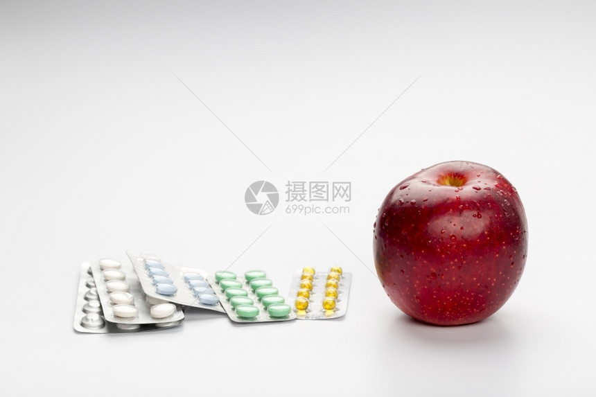 营养丰富红苹果和药丸彩色药丸在白背景的泡中饮食四肢图片