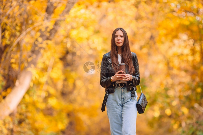 美丽的女人走在秋天公园概念公园的美丽女人在秋天的落叶下户外女士子图片