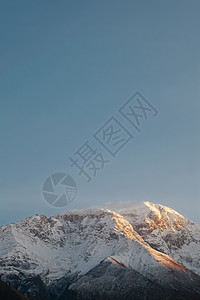 旅游宣传册整套巴基斯坦GilgitBaltistanHunzaNagar山谷的清蓝天空日落时对卡拉科姆山脉雪盖峰的垂直自然景观视图极简主义者蓝背景