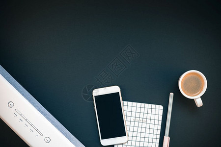 平坦的女办公桌工作空间的顶端视野平板白色立体蓝牙音屏和智能手机用于音乐监听和咖啡杯黑背景模板上有复制空间供博客社交媒体使用条形音背景图片
