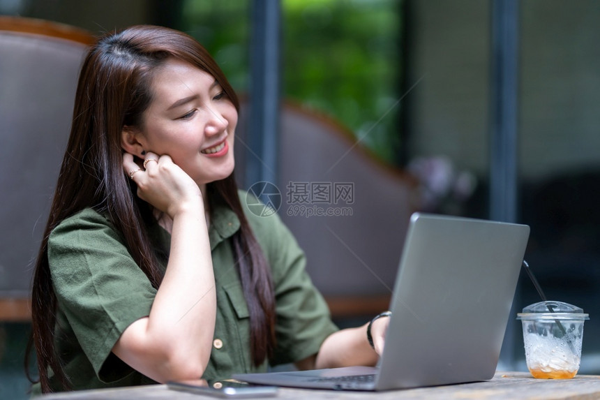 女在咖啡店用笔记本电脑工作手持咖啡杯和智能手机如背景沟通概念等校对Portnoyun白色的女士家图片